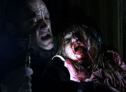 Un fotograma de <i>REC 2,</i> con un policía luchando contra una niña zombi.