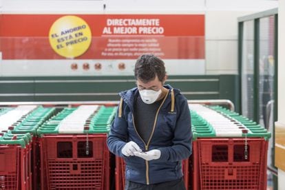 Un hombre mira su móvil en un supermercado de Madrid.