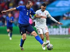 El defensa italiano Giorgio Chiellini (I)  disputa el balón con el mediocentro español Pedri (D) en las semifinales de la Eurocopa