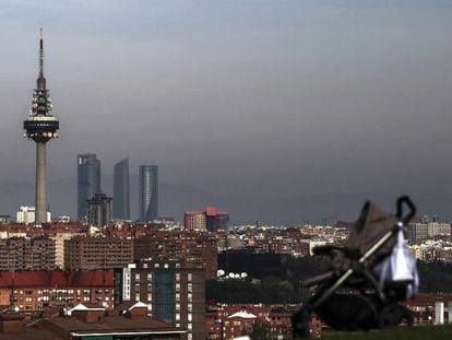 Un hombre con su beb&eacute; pasea por el barrio de Entrev&iacute;as, en Madrid.