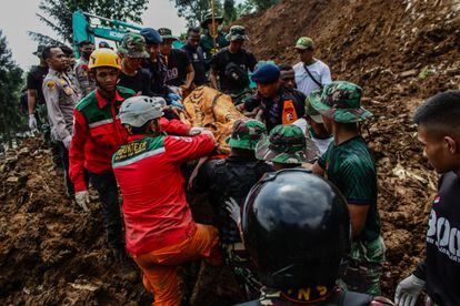 Unos trabajadores de los servicios de rescate de Indonesia evacuan a una víctima de un desprendimiento en Cianjur, este martes. El personal de emergencia está trabajando este martes contra el reloj para localizar y rescatar a posibles supervivientes del terremoto.  