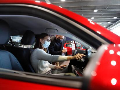 Un empleado muestra el vehículo a una clienta en un concesionario de coches de Terrassa.