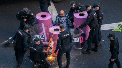 Agentes de la policía intentan retirar de la calzada a los activistas de Extinction Rebellion que han cortado la Gran Vía de Madrid este lunes.