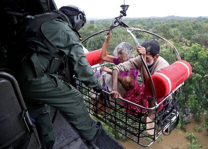 Una afectada por las inundaciones en el estado indio de Kerala es transportada por los soldados de la Armada india durante una operación de rescate, el 17 de agosto de 2018.