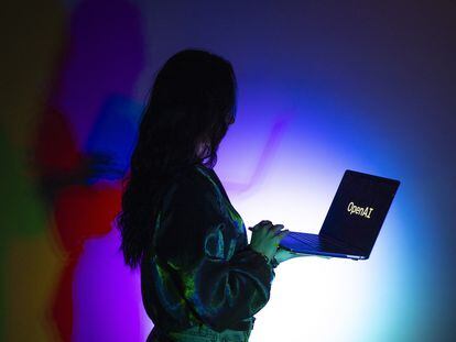 Una mujer mira la pantalla de un ordenador portátil que muestra el logotipo de OpenAI, la empresa creadora de ChatGPT.