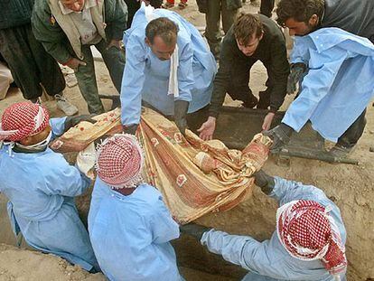 Voluntarios iraquíes ayudan a enterrar el cadáver de una mujer no identificada en la ciudad de Faluya.