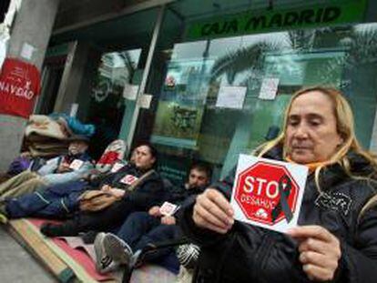 Miembros de la plataforma Stop Desahucios de la acampada Bankia Alicante cumplen 32 días de protesta a las puertas de una oficina de Caja Madrid en la avenida de la estación de Alicante.EFE/Archivo