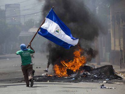 Un joven corre con una bandera en Masaya (Nicaragua) durante una serie de disturbios.