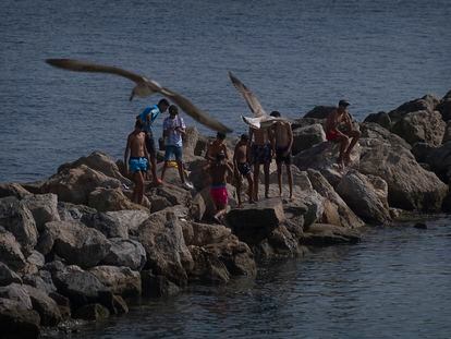 Menores marroquíes que llegaron a Ceuta en el cruce masivo de mayo de 2021, en un espigón de la playa de La Ribera, en la ciudad autónoma, el miércoles.