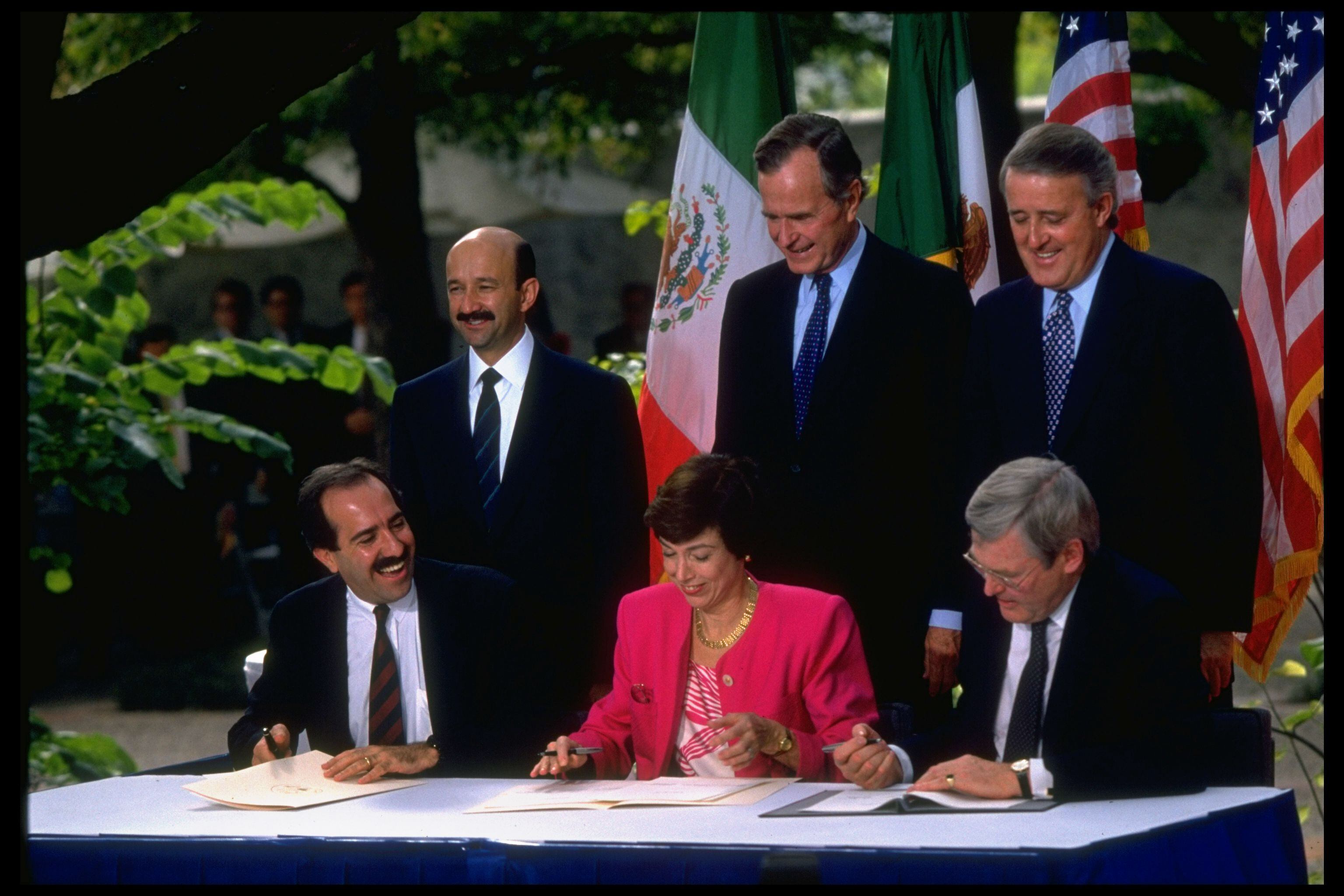 Los presidentes Mulroney, Bush y Salinas de Gortari de pie junto a sus respectivos representantes en la firma del Tratado de Libre Comercio. 