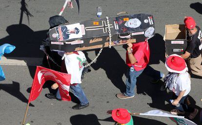 Unos protestantes llevan un ataúd falso en el que se encuentra el presidente Michel Temer.