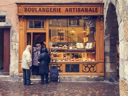 Algunos vecinos hacen cola en una panadería de la localidad francesa de Annecy.