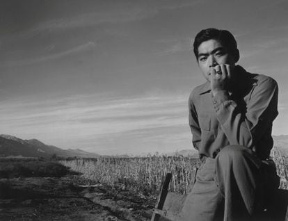 Un hombre sentado en un campo del Centro de Reubicación de Guerra de California, 'Manzanar', en 1943.
