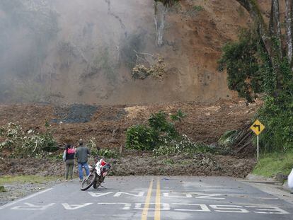 Dos personas observan una carretera bloqueada tras el derrumbe del pasado lunes en Rosas, departamento del Cauca, Colombia.