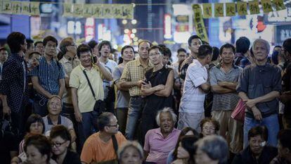 Un grupo de personas escucha un discurso improvisado por organizadores del movimiento prodemocracia en Hong Kong, este lunes.