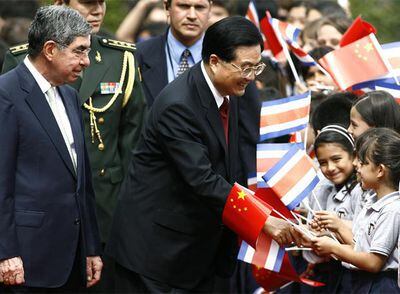 El presidente Jintao saluda ayer en San José a un grupo de niños, acompañado por Óscar Arias.