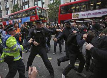 La policía carga contra los participantes en la manifestación convocada por la Confederación británica de sindicatos (TUC, siglas en inglés), en Londres (Reino Unido) hoy, sábado 20 de octubre de 2012 contra los recortes impuestos por el Gobierno de David Cameron y defendió una política alternativa a las medidas de austeridad.
