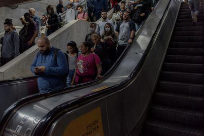 People walking down the escalators of Carioca metro station after a day of work.