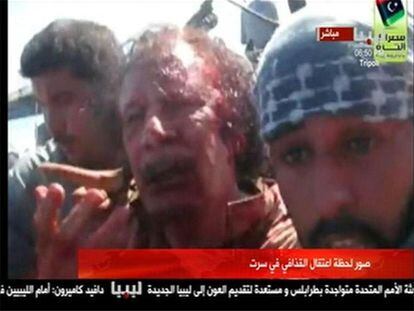 Imagen tomada de un vídeo en la que se ve a Gadafi aún vivo, poco después de ser apresado en Sirte.