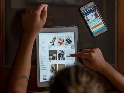 Una mujer utiliza una tableta para comprar zapatos por Internet.