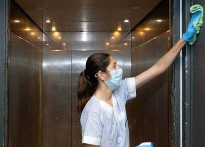 -Una limpiadora desinfecta un ascensor