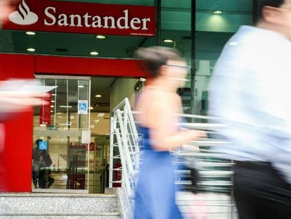 Personas pasan por delante de una sucursal del Banco Santander.