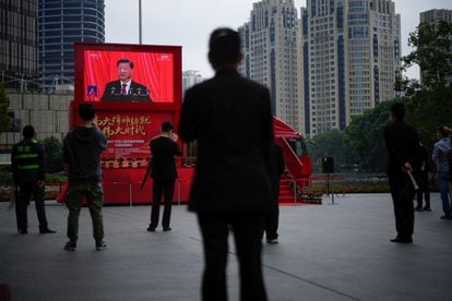 Ciudadanos siguen la transmisión del presidente chino, Xi Jinping, desde una calle de Shanghái este domingo.