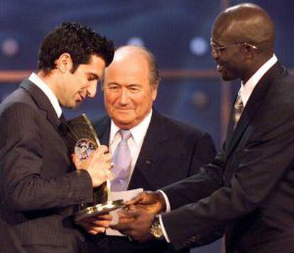 Figo recibe el premio a jugador del año 2001 de las manos de Weah y ante la mirada de Joseph Blatter.