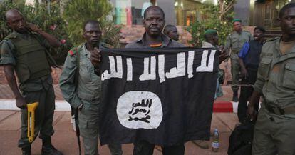 Agentes maliense muestran una bandera yihadista hallada en un hotel de Bamako, atacado en noviembre de 2015.
