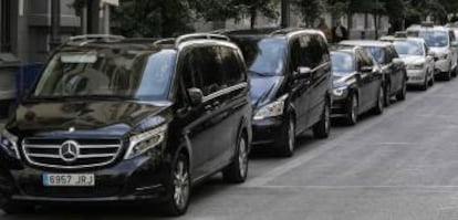 Una fila de vehículos de alquiler con conductor (VTC) y taxis en una calle de Madrid.