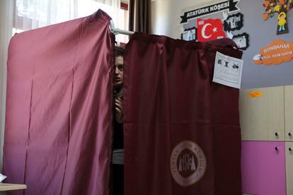 Una mujer sale de una cabina antes de votar en un centro electoral d'Ankara, este domingo.