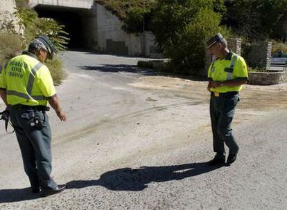 Dos agentes de la Guardia Civil investigan en la carretera A-4003, en el término municipal de Huétor Santillán, donde ha ocurrido el accidente mortal.