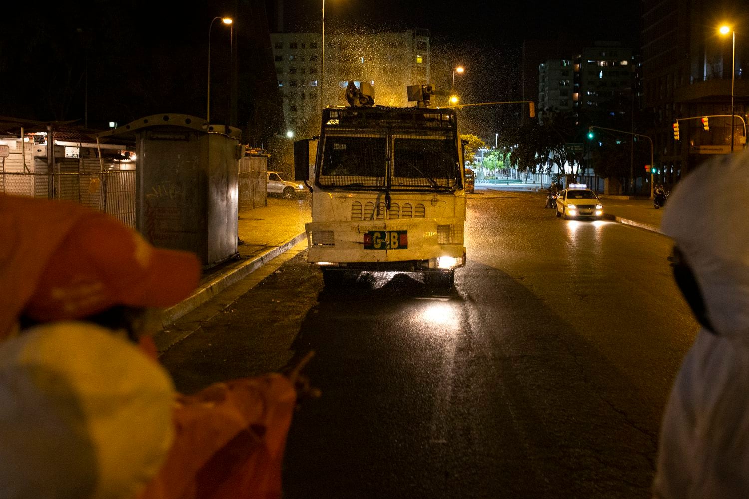 Un vehículo de la policía local rocía con hipoclorito de sodio una calle de Caracas.