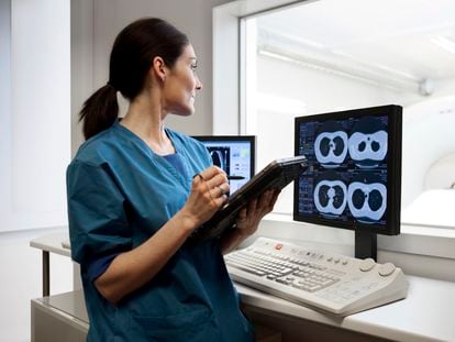 Una enfermera observa las imágenes tomadas por un escáner de tomografía computerizada.