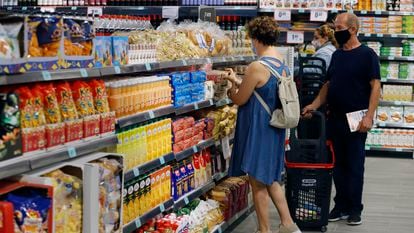 Unos clientes eligen productos en el supermercado.