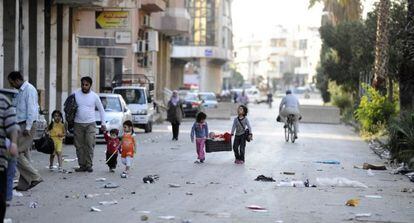 Unos ni&ntilde;os caminan en una de las calles de Homs. 