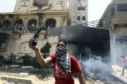 Un opositor al presidente egipcio, Mohamed Mursi, sostiene una pistola presuntamente utilizada por miembros de los Hermanos Musulmanes e incautada en un asalto a su sede principal en al-Moqattam, en el Cairo (Egipto), 1 de julio de 2013.