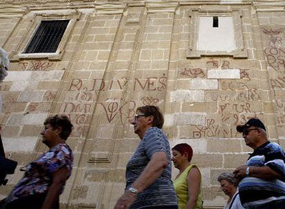 Fachada de la catedral de Sevilla, a la altura de la calle Alemanes. En la pared se pueden ver distintas inscripciones.