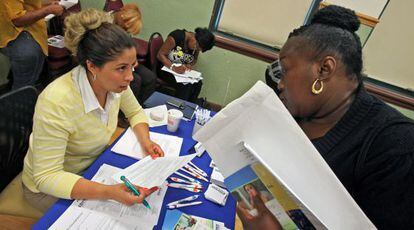 Una mujer entrega una solicitud en una feria de empleo en Chicago.