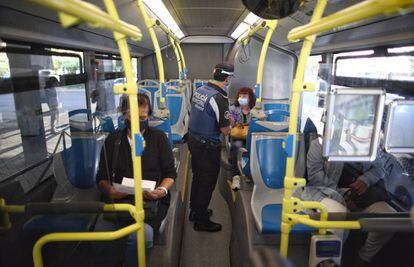 Un agente de la Policía Municipal de Madrid realiza un control de movilidad en una línea de autobús que pasar por el distrito de Puente de Vallecas (Madrid).