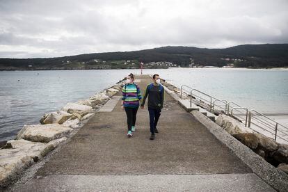 Una pareja pasea por el puerto de Laxe (A Coruña).
