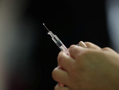 Una enfermera prepara una vacuna para la campaña estacional contra la gripe.