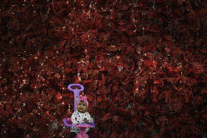 Una niña juega cerca de un árbol de Navidad en Caracas (Venezuela). El país sudamericano tiene uno de los índices más bajos del mundo en cuanto a contagios y fallecidos por esta pandemia que ha alcanzado en el globo a más de 80 millones de personas y se ha cobrado la vida de casi 1,8 millones.