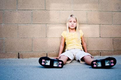 Ni&ntilde;a sentada llevando zapatillas con ruedas. 