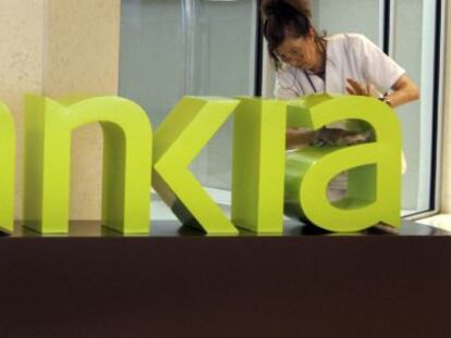 Una operaria limpia el logo de Bankia. EFE/Archivo