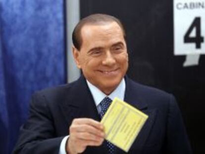 Former Prime Minister Silvio Berlusconi smiles as he casts his vote at the polling station in Milan, February 24, 2013. Italians began voting on Sunday in one of the most closely watched elections in years, with markets nervous about whether it can produce a strong government to pull Italy out of recession and help resolve the euro zone debt crisis. REUTERS/Stefano Rellandini  (ITALY - Tags: POLITICS ELECTIONS) ITALY-VOTE/