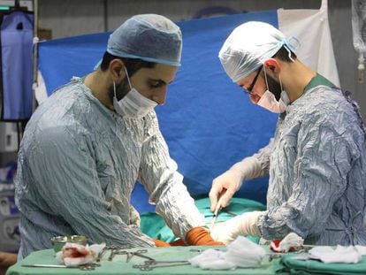 Dos profesionales sanitarios operan en un hospital sirio.