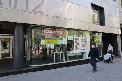 Un hombre con mascarilla pasa frente a una oficina de empleo en Madrid.