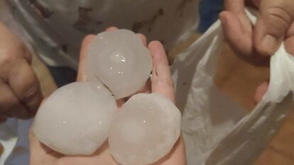Una persona enseña algunas de las piedras de hielo que cayeron ayer en La Bisbal.