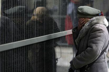 Una mujer llora ante el muro de v&iacute;ctimas del museo del Holocausto de Budapest en enero. 